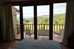 a bedroom with a bed and a view of a balcony at Casa da Belavista in Vilar de Nantes