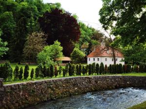 a house and a stone wall next to a river at Villa Taborec in Samobor