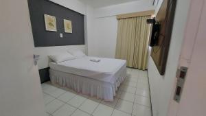 um pequeno quarto com uma cama num quarto em Flat Biarritz - Ao lado da Litoranea - Ferreira Hospedagens em São Luís