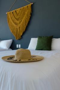 un sombrero de paja sentado en la parte superior de una cama en Sanyama Holbox, en Isla Holbox