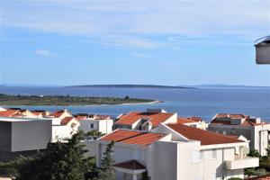 eine Gruppe von Häusern mit dem Ozean im Hintergrund in der Unterkunft Novalja Penthouse Apartment in Novalja