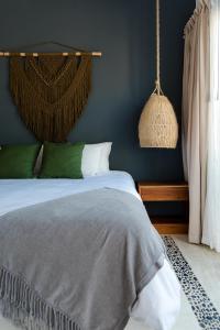 1 dormitorio con cama y pared azul en Sanyama Holbox, en Isla Holbox