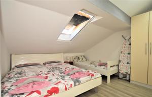 Schlafzimmer im Dachgeschoss mit einem Bett und einem Fenster in der Unterkunft Novalja Penthouse Apartment in Novalja