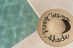 un cappello di paglia seduto accanto alla piscina di Sanyama Holbox a Isola Holbox