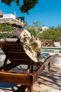 un cappello seduto su una panchina accanto a una piscina di Sanyama Holbox a Isola Holbox