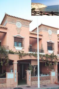 サン・ファン・デ・ロス・テレロスにあるApartamento La Invencible Terreros en 1ª Línea de Playaの時計付ピンクの建物