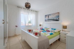 biała sypialnia z łóżkiem i biurkiem w obiekcie Apartment Tropicos w mieście Carvoeiro