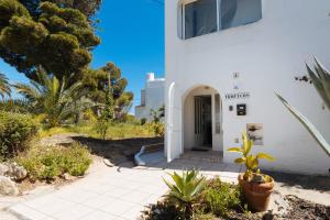 a white building with a door in a yard at Apartment Tropicos in Carvoeiro