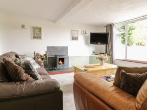 a living room with two couches and a fireplace at Cyffdy Cottage - Aran in Llanycil