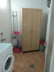 a bathroom with a washing machine and a wooden cabinet at Casa Relajación in Santa Cruz de Tenerife