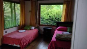 1 dormitorio con 2 camas y ventana grande en Hotel Selva Verde, en Salento