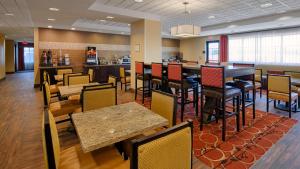 a restaurant with tables and chairs and a bar at Best Western Plus Desert Poppy Inn in Lancaster