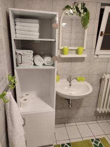 a white bathroom with a sink and towels at Apartman Stara pruga in Sarajevo +15 photos