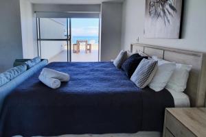a bedroom with a blue bed with a view of the ocean at Surfers Chalet in Gold Coast +29 photos