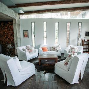 a living room with white couches and a table and windows at Altos de la Serena Apart Hotel in La Paloma