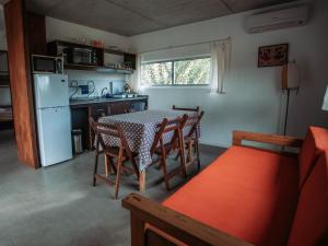 a kitchen with a table and chairs and a refrigerator at Altos de la Serena Apart Hotel in La Paloma