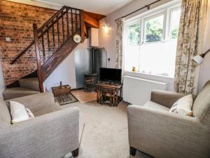 a living room with two couches and a staircase at The Mill Wheel in Ashbourne