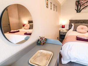 a bedroom with two beds and a mirror at The Mill Wheel in Ashbourne