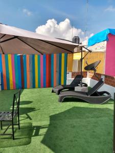 - une terrasse avec 2 chaises sous un parasol dans l'établissement La Catrina Hostel, à San Miguel de Allende
