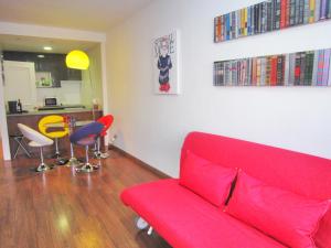 マドリードにあるApartamento GP JUNTO AL PARQUE DEL RETIROのリビングルーム(赤いソファ、椅子付)