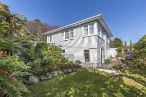 una casa blanca con un patio delante en Lemon Tree Apartment Tawa en Wellington
