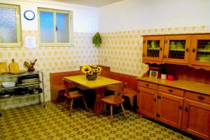 uma cozinha com uma mesa e cadeiras numa cozinha em Casa Poggio dei Pini em Baselga di Pinè