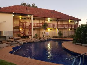 a swimming pool in front of a building with a house at Vine Inn Barossa in Nuriootpa