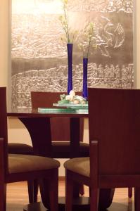 a dining room table with two chairs and blue vases at Jinling Resort Nanjing in Nanjing