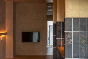a room with a tv and a wall with tiles at Seven Stories in Nagoya