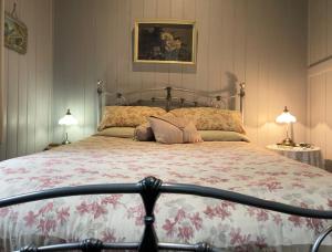Un dormitorio con una cama grande con flores. en Belvoir B&B Cottages en Grafton