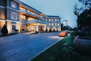 un coche naranja estacionado frente a un edificio en Dalat Edensee Lake Resort & Spa, en Da Lat