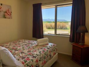 1 dormitorio con cama y ventana en Stunning 360-degree views en Twizel