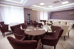 a restaurant with tables and chairs in a room at Hotel Bardin in Novokuznetsk