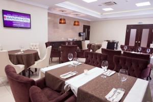 a dining room with tables and chairs with wine glasses at Hotel Bardin in Novokuznetsk