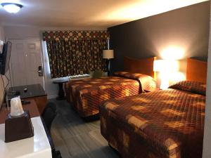 a hotel room with two beds and a table at Budget Inn & Suites in Amarillo