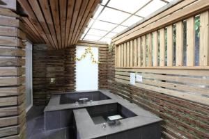 ein großes Bad mit einem Waschbecken und einem Fenster in der Unterkunft Hotspring World Wulai in Wulai