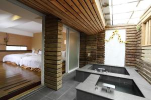 un bagno con vasca e una camera con letto di Hotspring World Wulai a Wulai