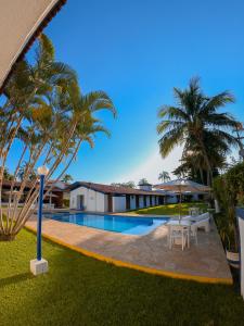 um resort com piscina e palmeiras em Hotel Arrastão em São Sebastião