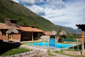 a house with a swimming pool in front of a mountain at Sacred Valley View in Urubamba