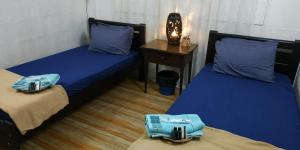 2 letti con cuscini blu in una stanza di RAHIM HOMESTAY KUALA KANGSAR a Kuala Kangsar