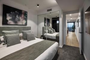 um quarto com 2 camas e um espelho grande em KT Apartments em Adelaide