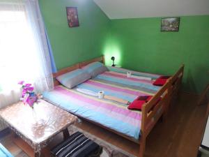 a large bed in a bedroom with green walls at Apartman MILENA in Foča