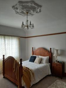 a bedroom with a bed and a chandelier at Wainono Homestead in Waimate