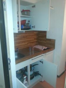 a kitchen with white cabinets and a sink at Studio sur les pistes in Bagnères-de-Bigorre