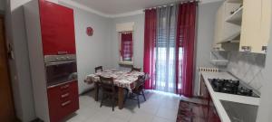 a kitchen with a table and a kitchen with red curtains at JR-ESCANIO in Ancona