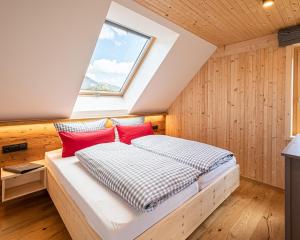 1 dormitorio con 1 cama con almohadas rojas en Nattrars Huimat, en Obermaiselstein