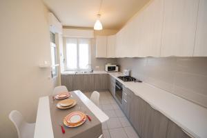 a kitchen with white cabinets and a table with plates on it at Casa Emmeti in Desenzano del Garda