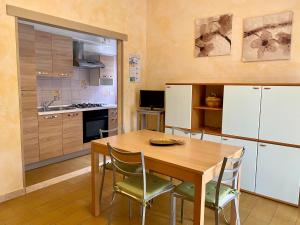 a kitchen with a wooden table and chairs in a room at Residence Mare Verde in Pietra Ligure