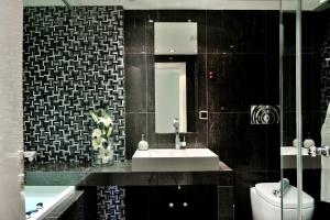 a bathroom with a sink and a toilet and a mirror at Sani Polyastron Hotel & Spa in Sani Beach