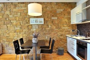 a kitchen with a table and chairs in front of a brick wall at Sani Polyastron Hotel & Spa in Sani Beach